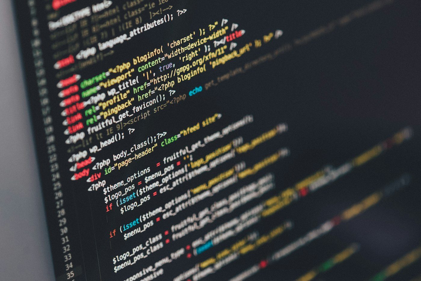 Two monitors on a desk showing source code in an IDE