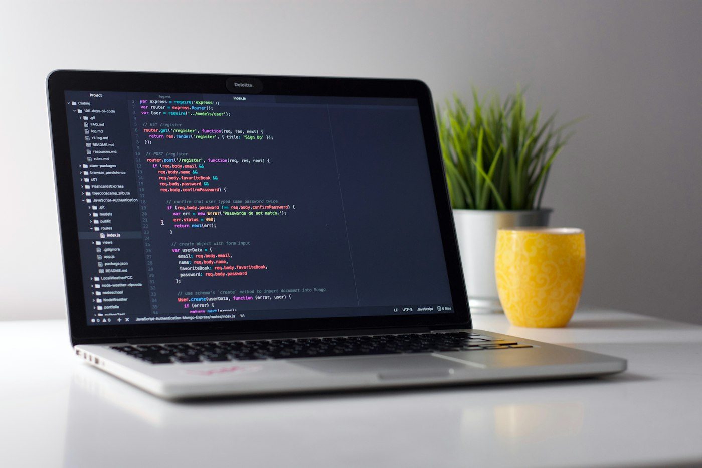 Open laptop on a desk with programming code visible on the screen